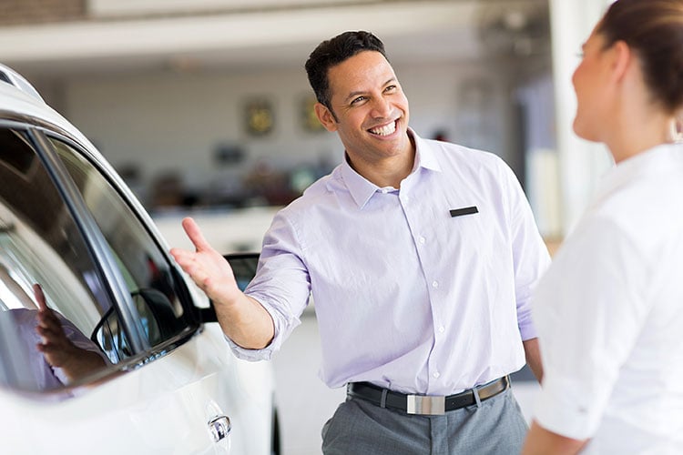 car sales representative presenting a car to customer